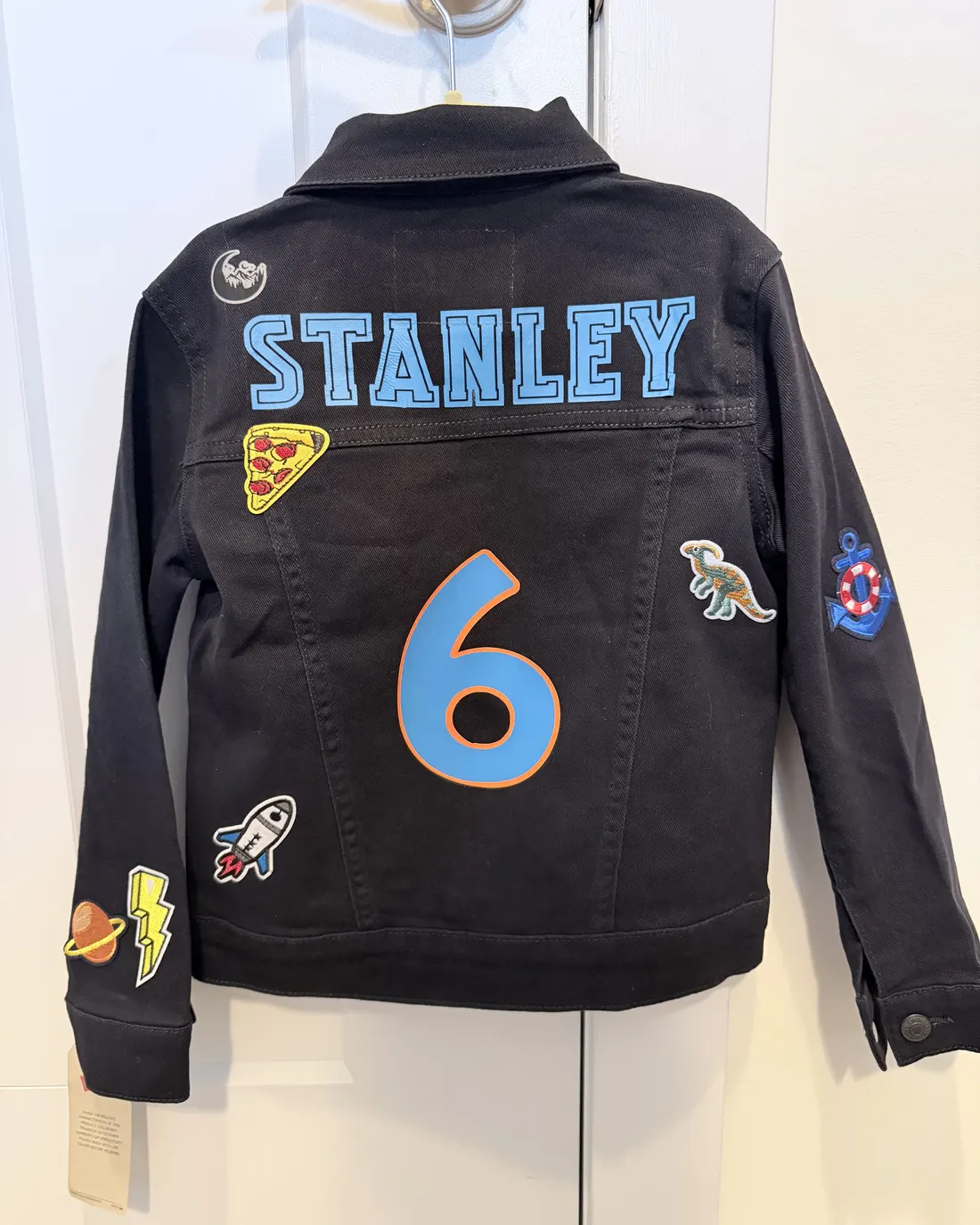 Black denim jacket with a name and a large number six