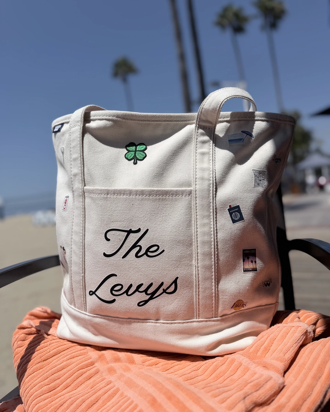 Cream canvas tote embroidered with a family name in script and small icons chosen for the family