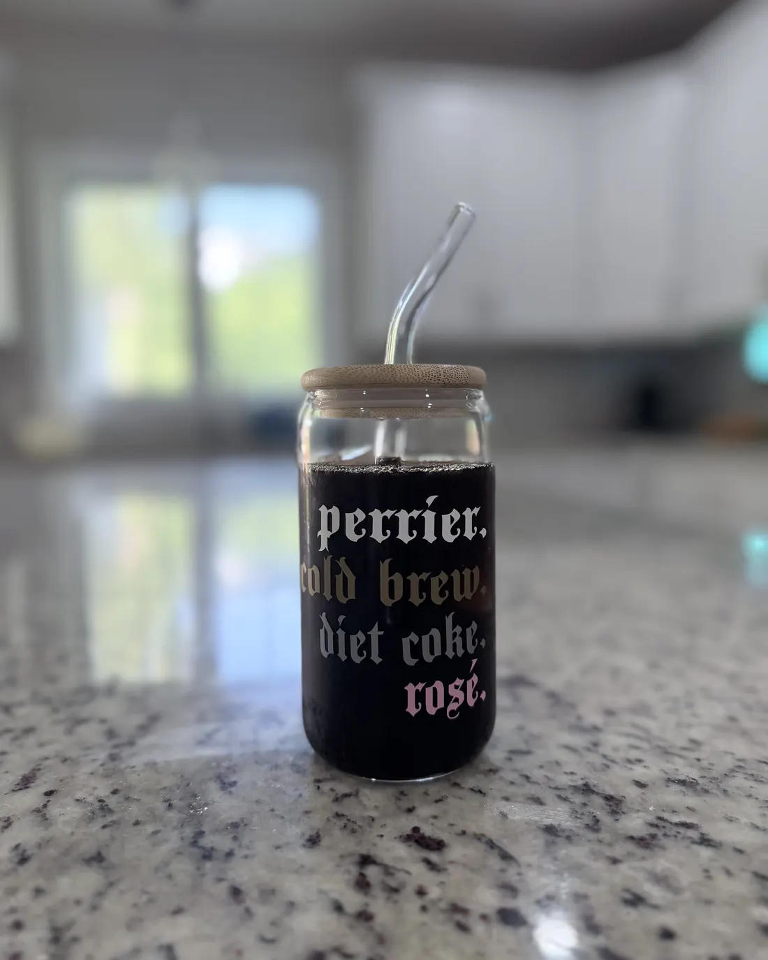 Glass can tumbler with a bamboo lid and glass straw, lettered with a favorite-drinks list