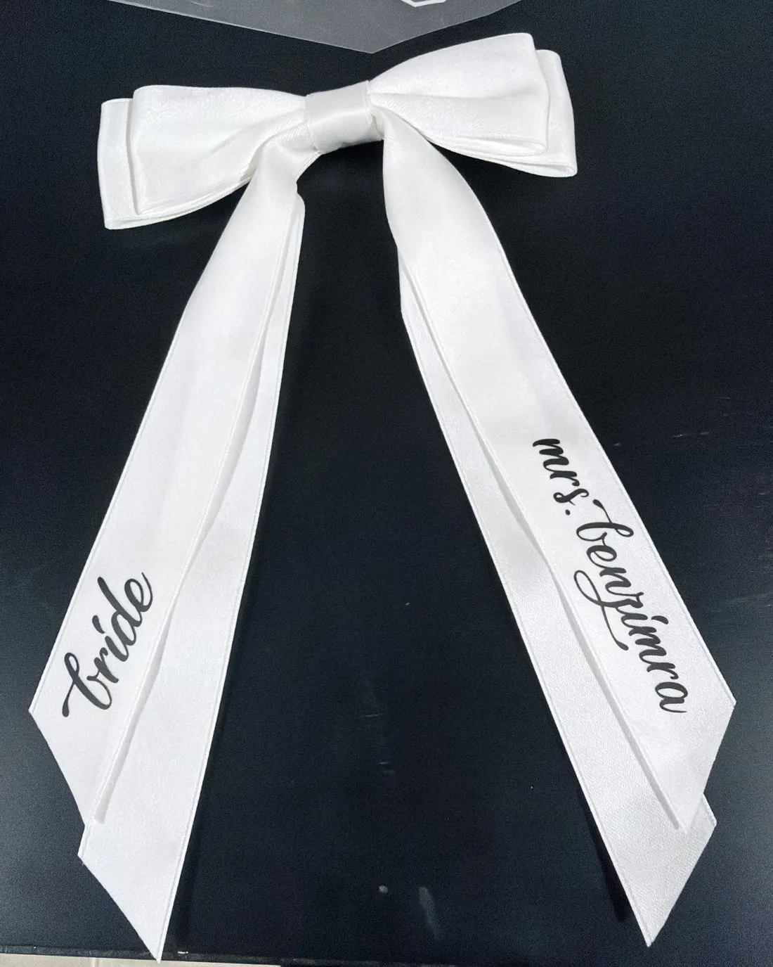 White satin bows lettered for the bride